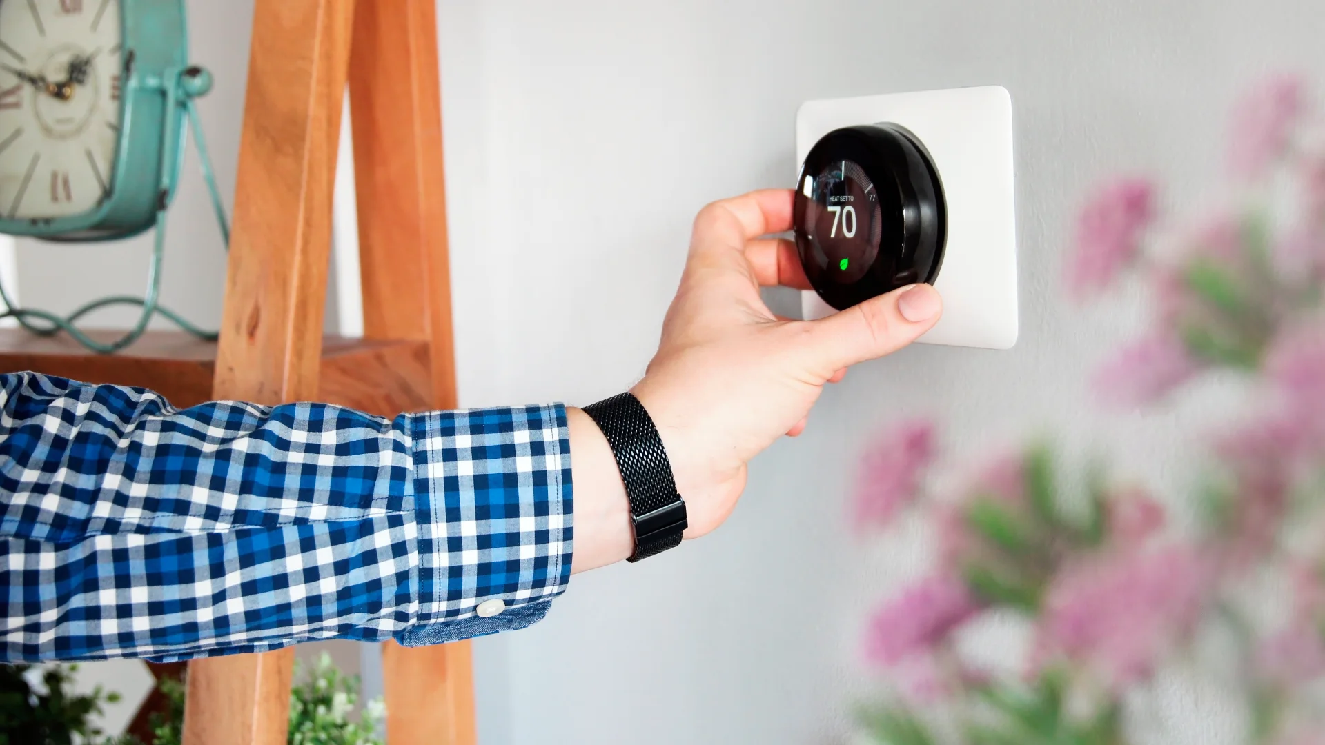 picture of homeowner adjusting wifi thermostat